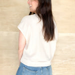 Taupe short sleeve top, slight cuffed sleeve, round neckline, front tie detail, cropped length
